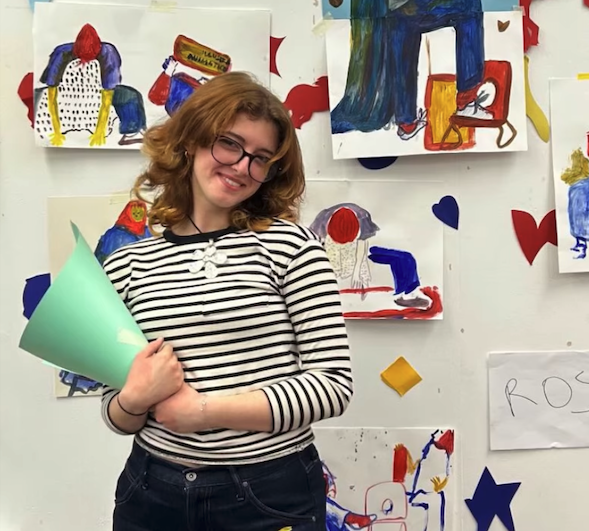 Erica Rose with her mini exhibition of hand-painted portraits